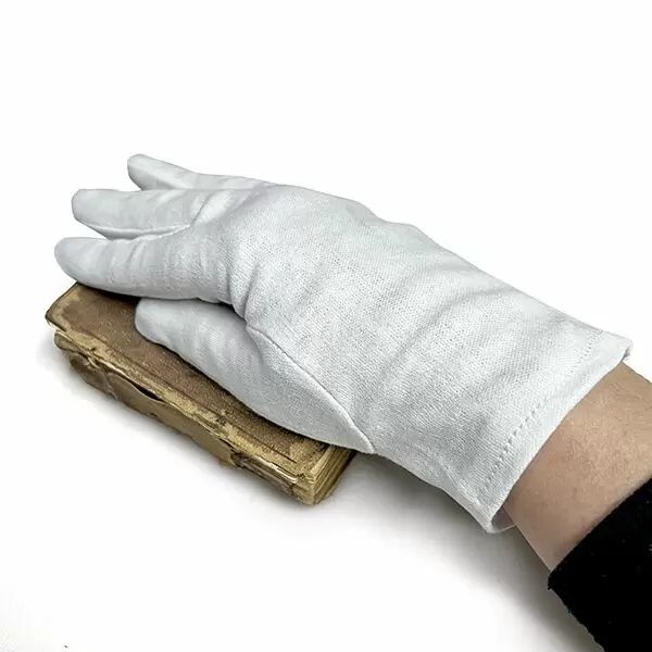 Main gantée de blanc manipulant un ancien tirage photographique